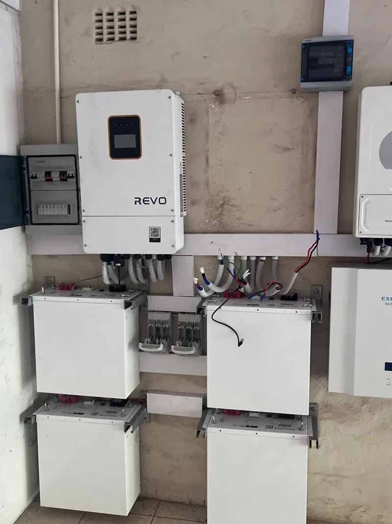 An inverter with four battery cabinets and distribution boards on a wall
