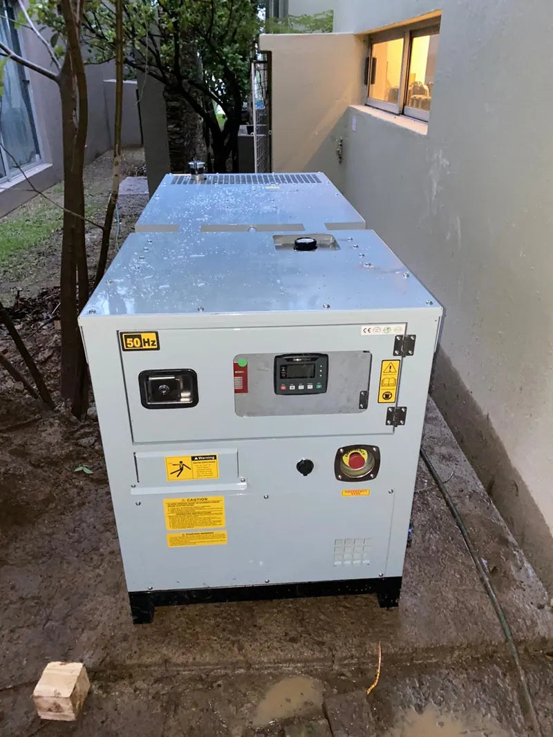 A silent diesel generator installed in a narrow garden beside a house