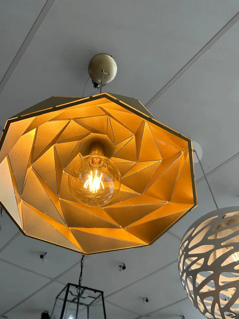A geometric pendant light with a filament bulb hanging from a ceiling